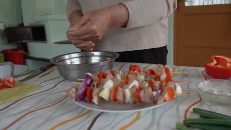 Manos-De-Una-Mujer-Mayor-Preparando-Brochetas-En-La-Cocina-Tradicional-Rumana