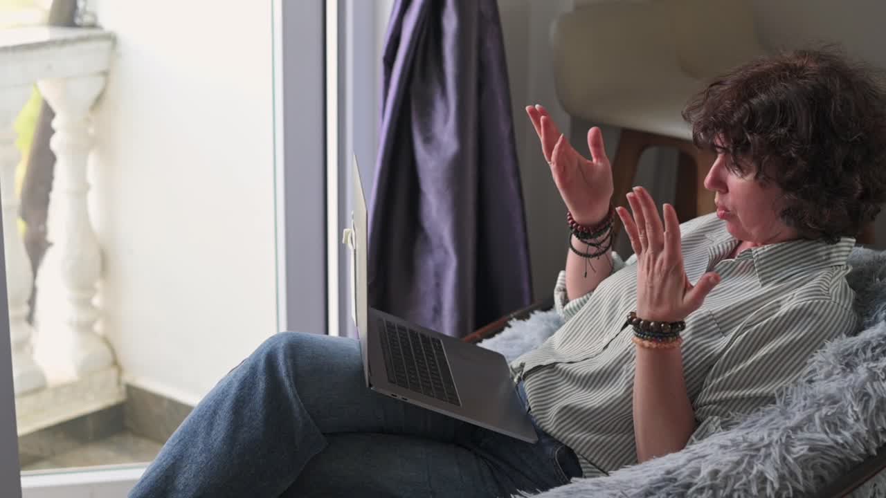 Dialogo digitale espressivo. Partecipante femminile coinvolta che scambia attivamente idee tramite dispositivo elettronico. Donna dinamica con gesti vivaci impegnata in una vivace conversazione online sul suo computer
