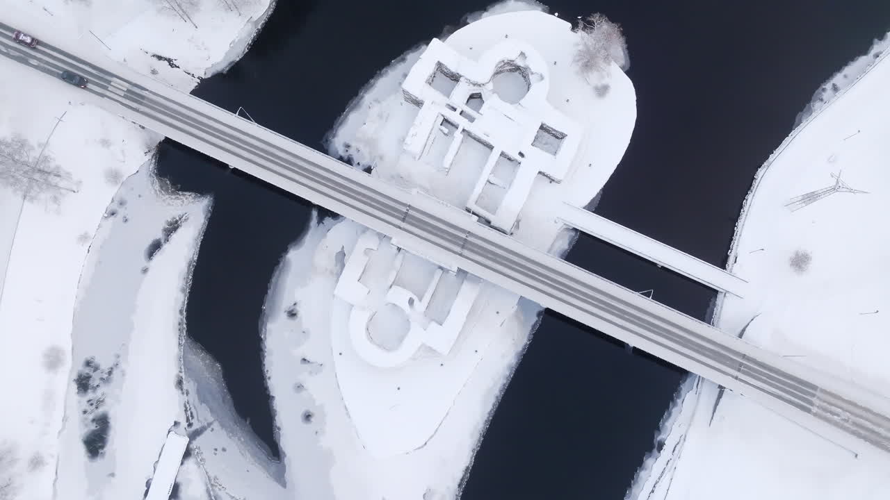 Aerial view tilting in front of the Kajaani castle, winter day in Kainuu, Finland