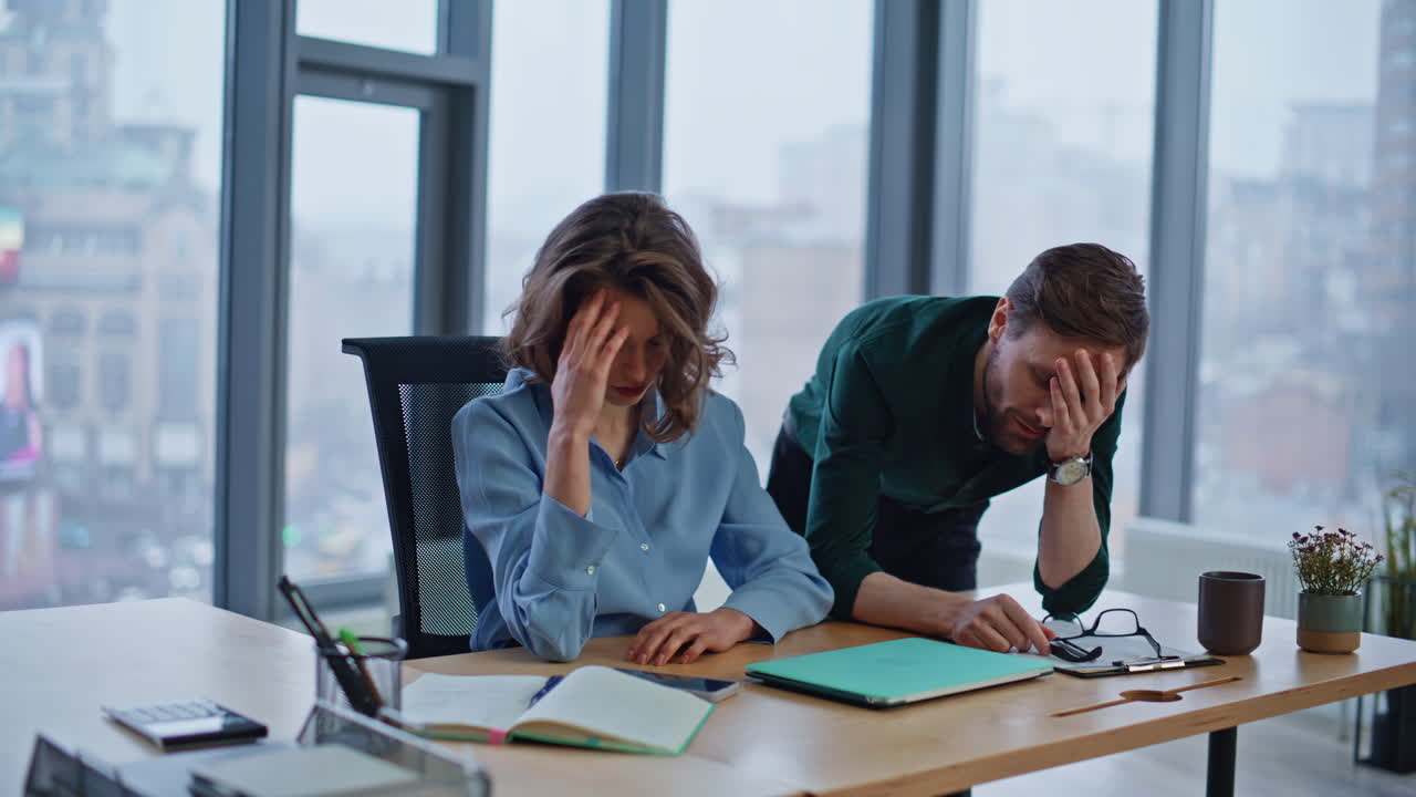 Frustrated partners losing money working laptop together at corporate office