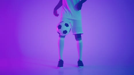 Black-african-man-Freestyle-or-professional-soccer-player-practicing-with-football-ball-juggling-on-legs-slow-motion.-Studio-shooting-of-a-professional-football-player-with-a-ball