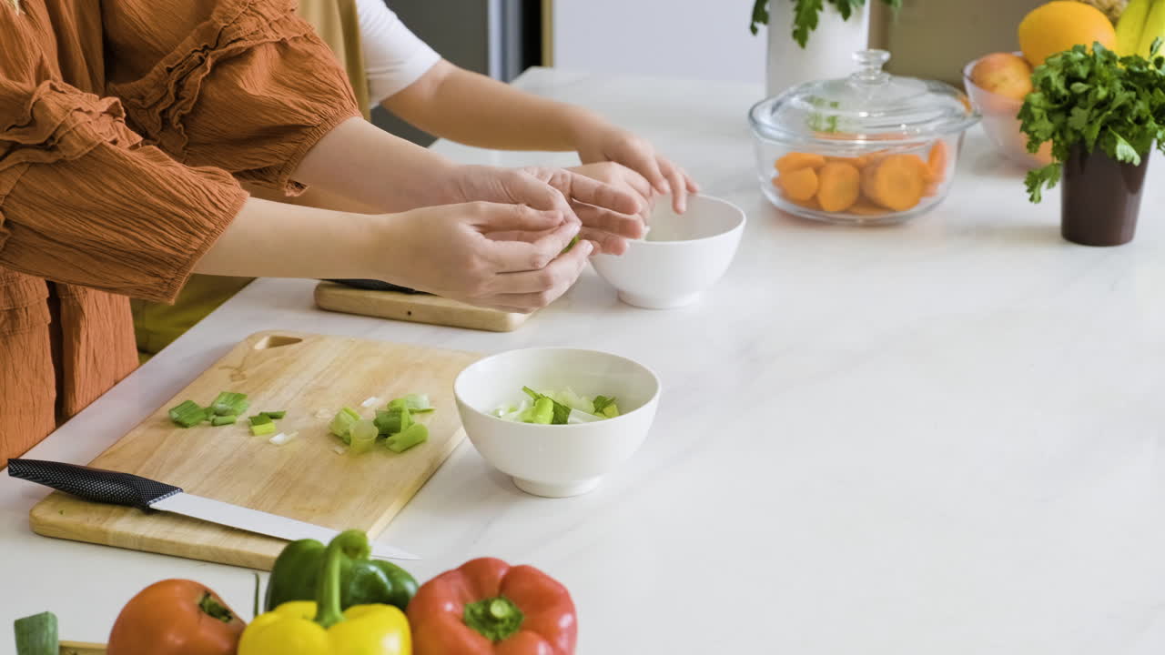 엄마와 소년이 부추를 그릇에 담습니다.