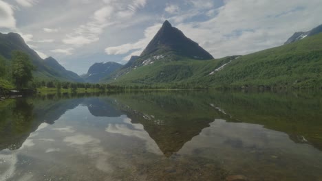 Beautiful-reflection-of-Innerdalstårnet-mountain-peak-on-a-serene-lake-in-Innerdalen-valley