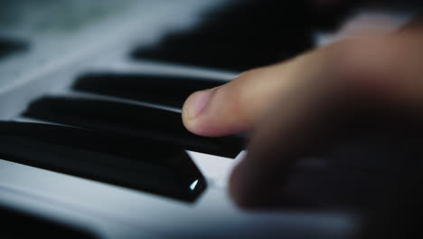 beautiful slow motion shot of a young professional male musician playing chords on the piano with two hands inside his home studio recording a song.
