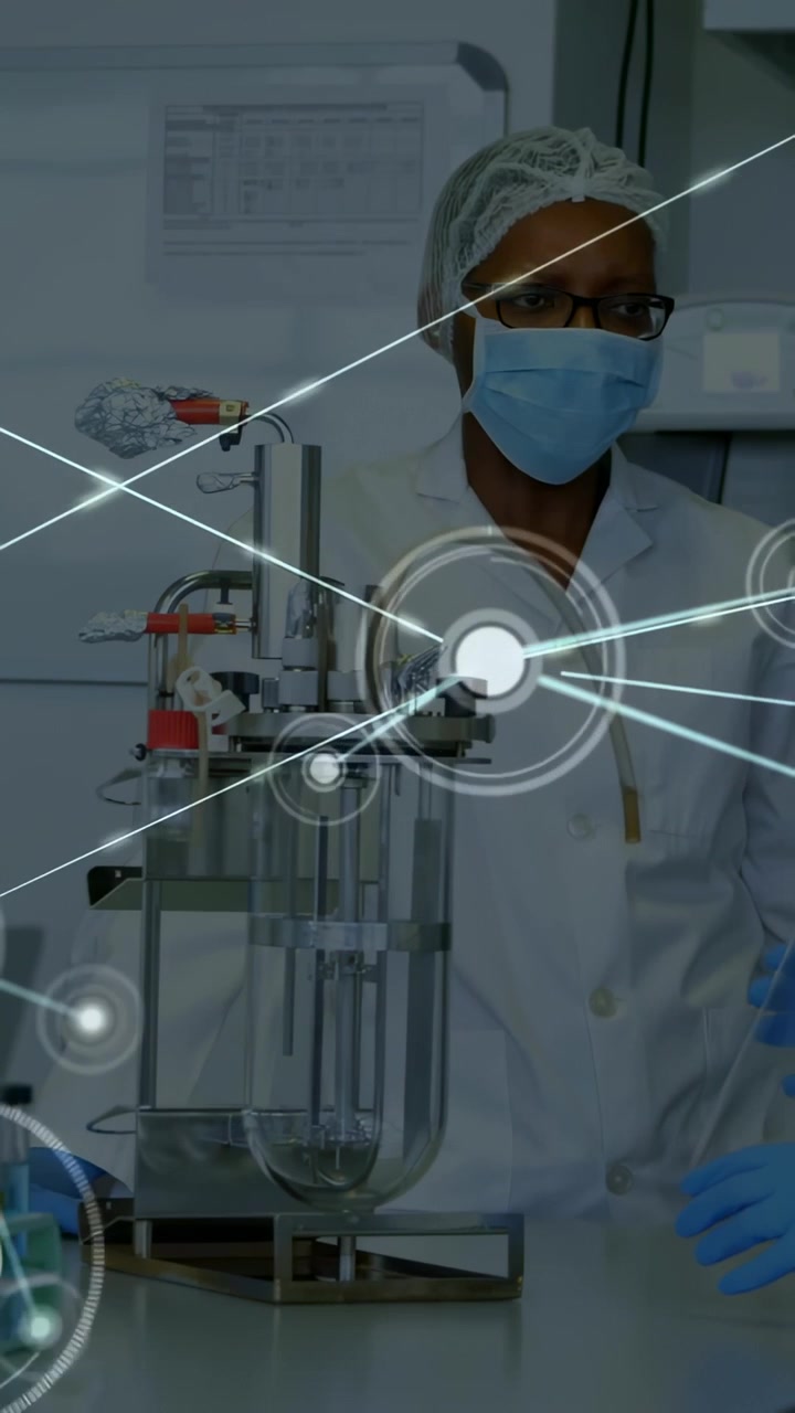 Vertical video: Watching tech at lab in coat gloves watching reactor as HUD growing, handling flask