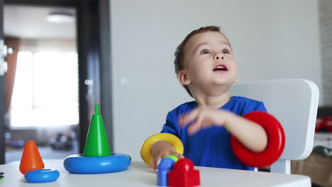 adorable kid holding the rings from pyramid on his hands. beautiful child smiling to the camera.