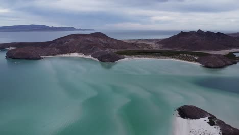 playa balandra with turquoise waters and mountainous backdrop, baja california, mexico, on a cloudy day, aerial view