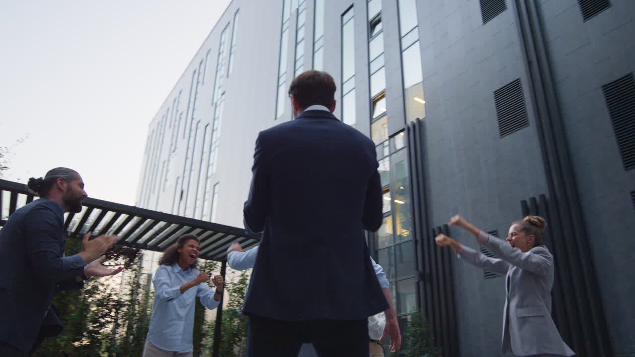 Happy team appreciate employee outside office building. Best worker recognition.