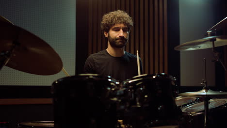 musician performing rock music in concert hall. drummer playing drum kit indoor.