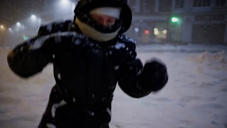 woman walking in a snowstorm at night