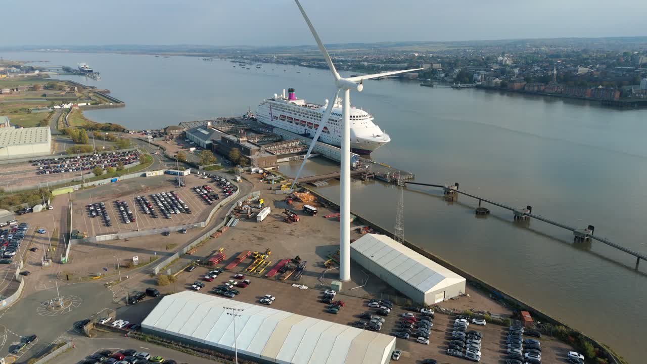 Vídeo aéreo con dron de un puerto industrial con actividad de importación y exportación y aerogeneradores en los muelles de Tilbury, Londres, Reino Unido