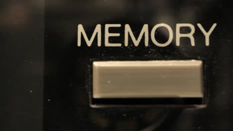 extreme close up of buttons on an old antique or vintage vcr short truck left revealing a memory button