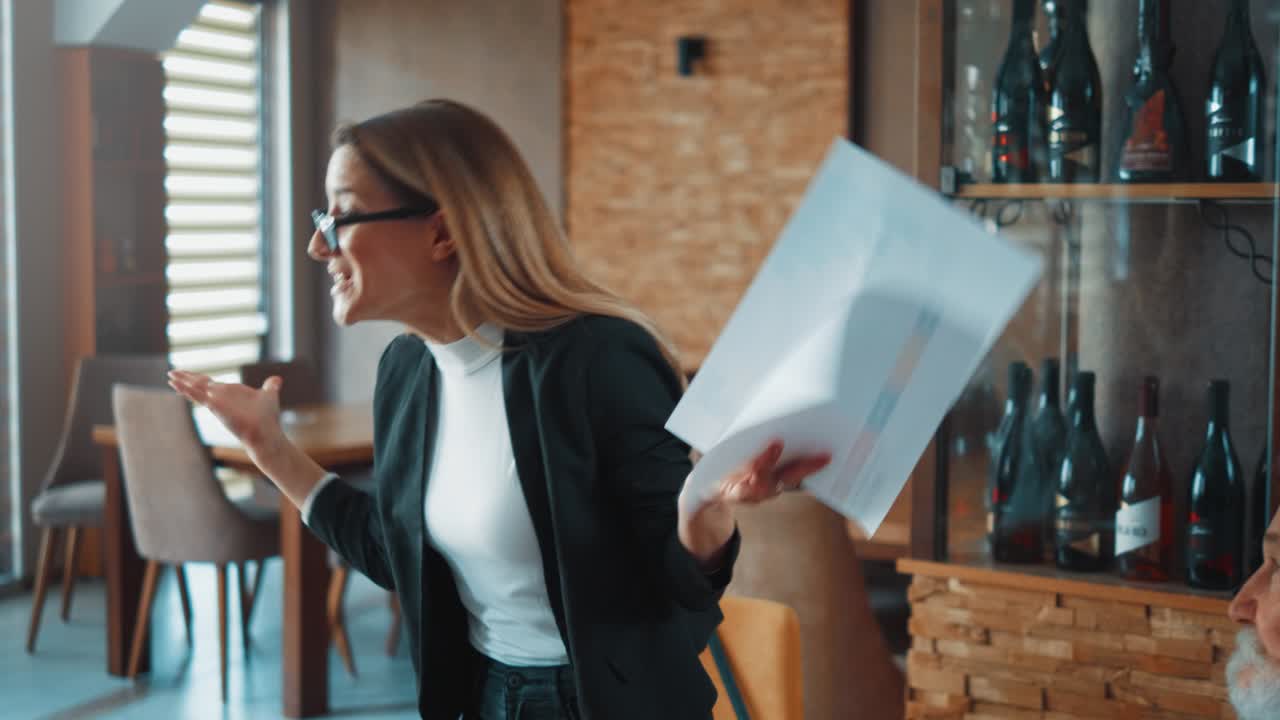 Group business people celebrate after female colleague get up and delivers good news in a restaurant business meeting