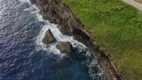 Aerial-view-of-waves-crashing-on-rocks-and-cliffs