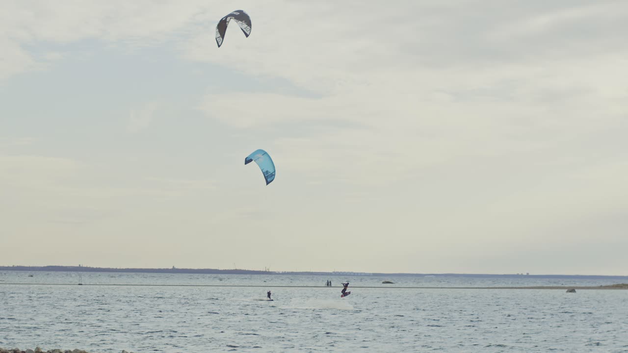 un hábil kitesurfista salta en el aire en cámara lenta, filmado en la costa nórdica de estonia