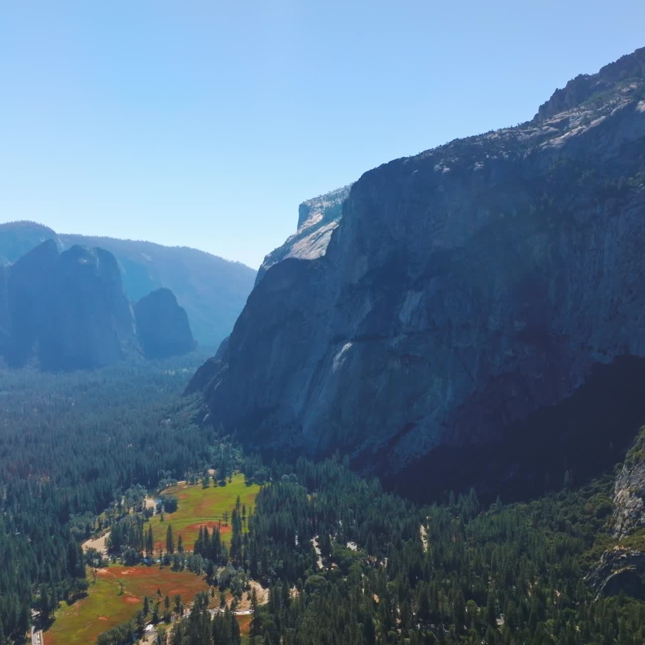 Bright sun lighting the beautiful valley among the huge mountains. Stunning scenery of Yosemite National Park, California, USA