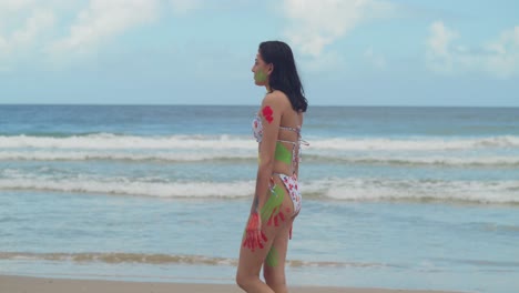 un soleado día del caribe proporciona el escenario perfecto para una chica con pintura corporal y un bikini caminando por una playa de arena blanca.