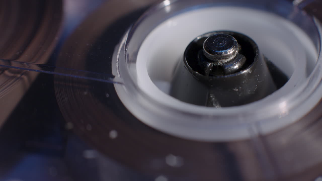 회전하는 마이크로카세트 레코더 릴에서 조명이 파란색으로 어두워짐