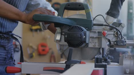 mid section of carpenter cutting wooden plank with electric saw 4k