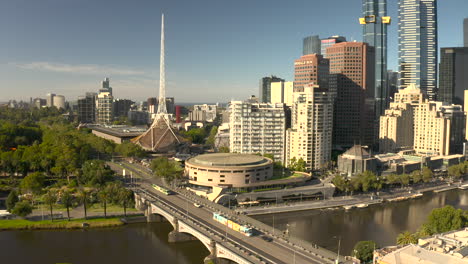 Vista-Aérea-De-Los-Coches-Que-Circulan-Sobre-Un-Puente-Sobre-El-Río-Yarra,-Con-Imponentes-Rascacielos-Al-Fondo.