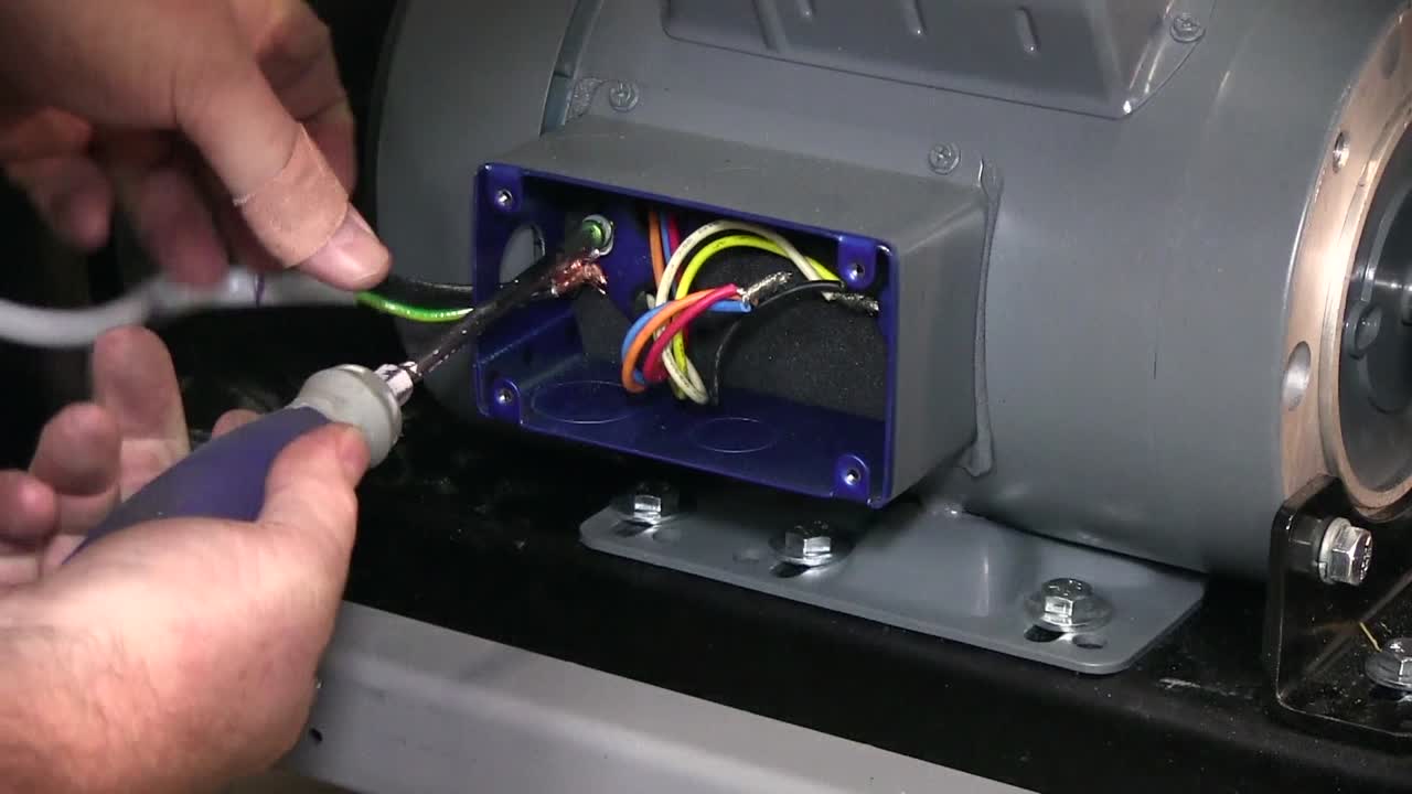 asegurar la conexión del cable en la maquinaria mezcladora de pintura usando un destornillador