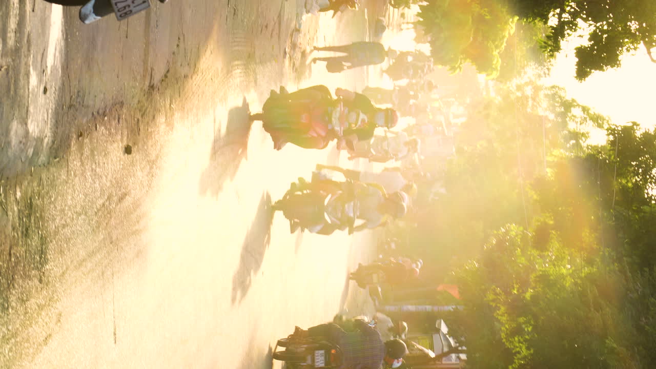 concurrida calle vietnam con motos durante la puesta de sol dorada, video vertical