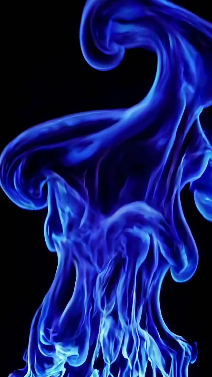 Video ravvicinato di vivaci fiamme blu che turbinano contro uno sfondo scuro, catturato da un'angolazione dal basso.