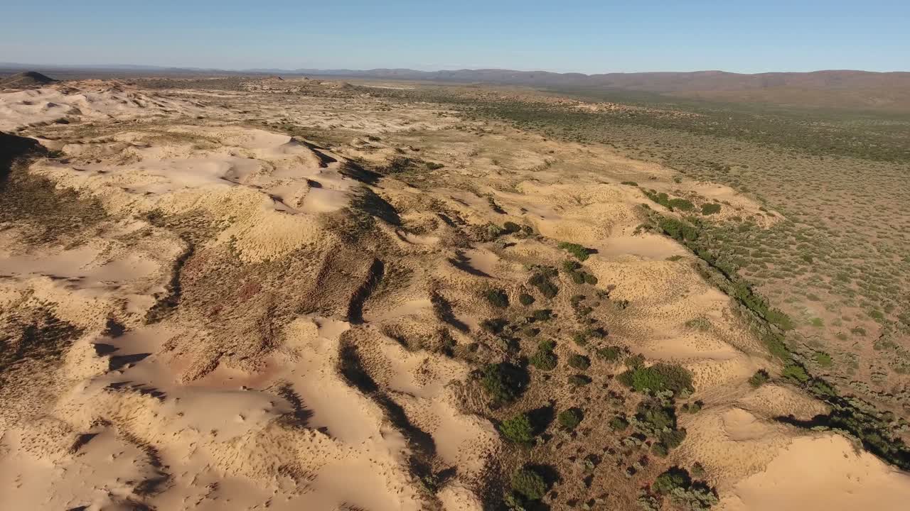 vista aérea de dunas de arena masivas entre montañas rocosas en la región árida del cabo norte, sudáfrica