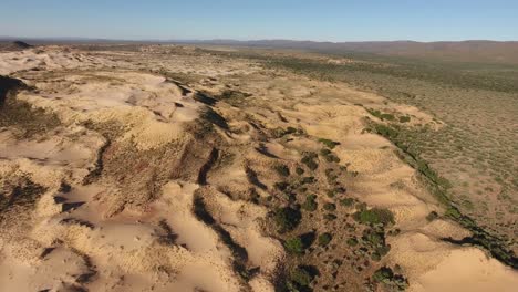 Vista-Aérea-De-Dunas-De-Arena-Masivas-Entre-Montañas-Rocosas-En-La-Región-árida-Del-Cabo-Norte,-Sudáfrica