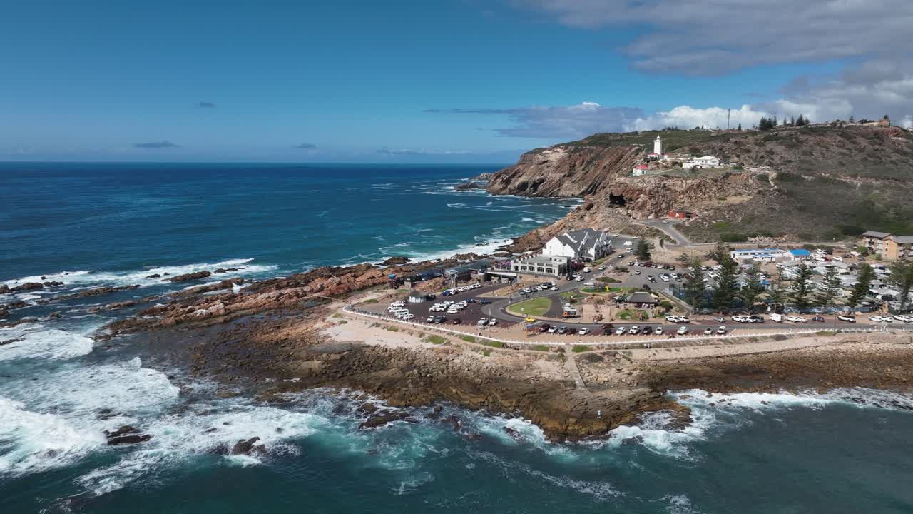 Soliga luftcirklar stenig havspunkt fyr vid Mossel Bay, RSA
