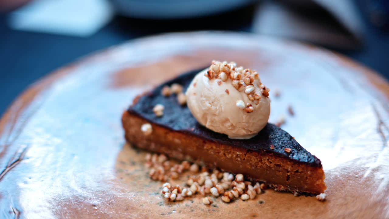 A piece of tart with ice cream on a plate, at a cafe