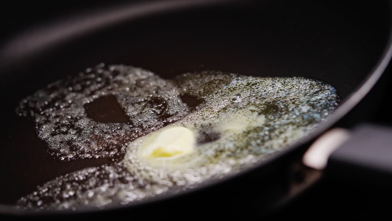 Melting butter in hot skillet foams and sizzles as it heats up and spreads across pan