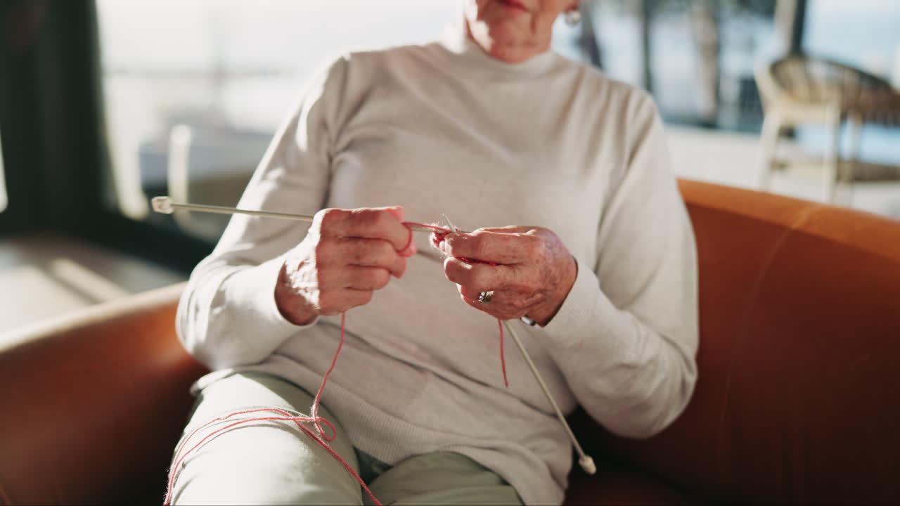 집에서 뜨개질하는 고령 여성