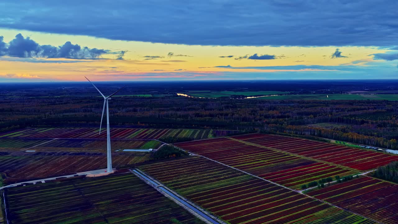 Veduta aerea all'ora d'oro di una turbina eolica terrestre che si erge sulla campagna coltivata