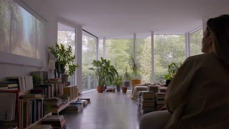 person relaxing in a modern living room with nature views and books