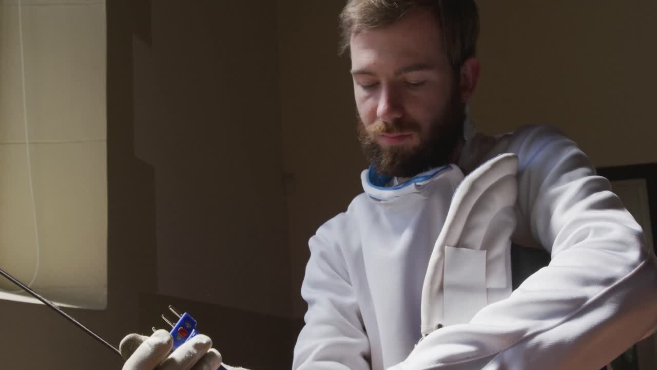 спортсмен во время тренировки по фехтованию в тренажерном зале