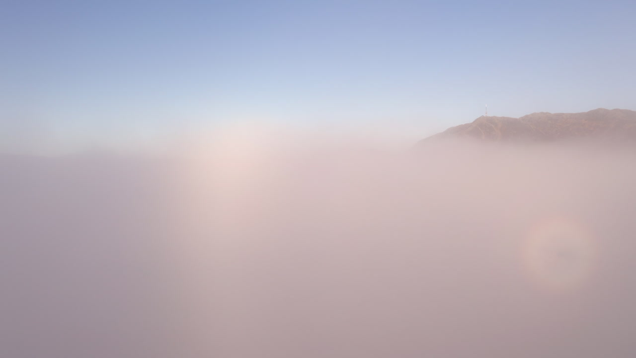 구름으로 가득 찬 산과 계곡을 드러내기 위해 두꺼운 구름을 뚫고 올라가는 드론 샷