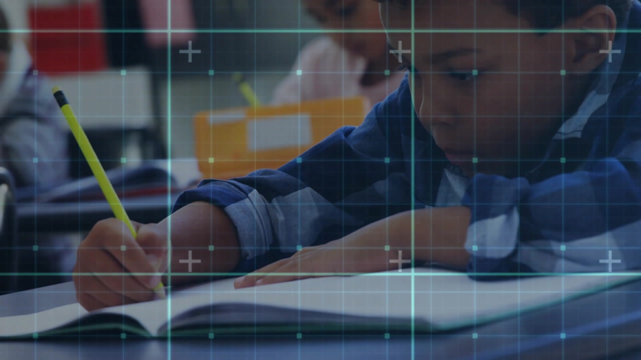 Student boy responding to grid overlay and writing lines in notebook to complete education exercise