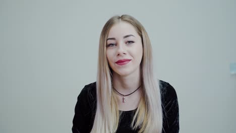 portrait of a blonde woman with bright lips. beautiful girl looking at camera and smiling isolated in studio.
