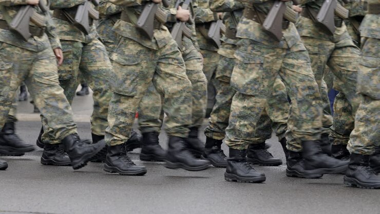 Soldati che marciano in uniforme mimetica