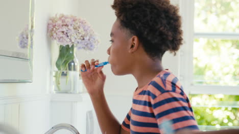 Brother-And-Sister-Sitting-In-Bathroom-At-Home-Brushing-Teeth-Together