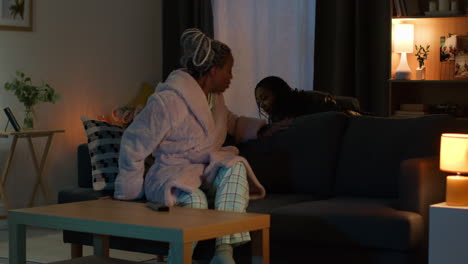 women relaxing on a couch at night