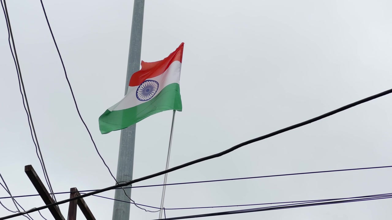 Indisk nationalflag vist på en høj mast under forberedelserne til en offentlig fejring af Uafhængighedsdagen eller Republikkens Dag i en indisk by