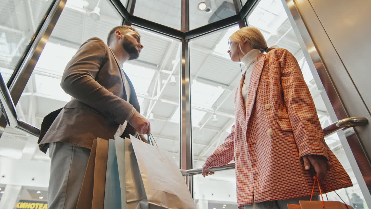Beautiful Couple In Glass Elevator At Shopping Centre