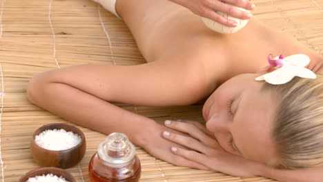 woman enjoying a herbal compress massage