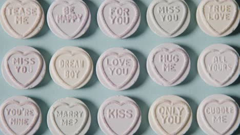 Full-Frame-Shot-Of-Heart-Candy-With-Romantic-Messages-Of-Love-On-Blue-Background