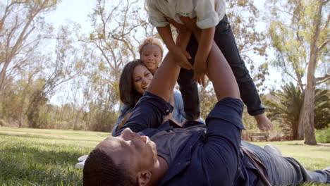 parents playing with their young kids in the park, low angle