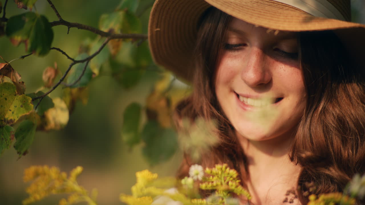 Pensive girl in hat with wildflowers