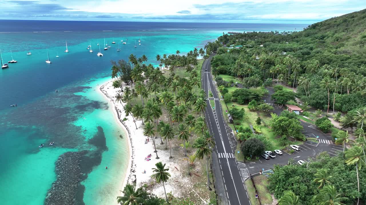 프랑스령 폴리네시아의 무레아 (moorea) 의 타야마누 해변과 인접한 도로를 가로질러 날아다니는 드론