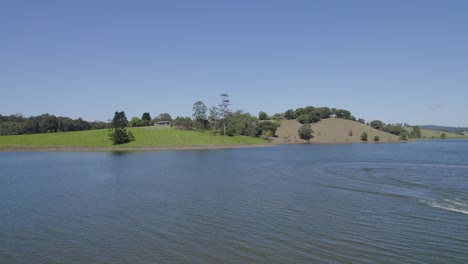 Speedboat-On-The-Waters-Of-Tinaburra-In-Summer-With-View-Of-Barrine-Town-In-Background